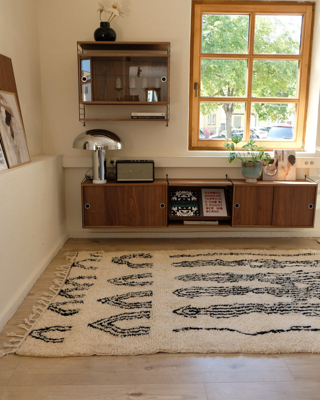 Azilal ZEBRA von der Schmalseite aus gesehen, vorne Reihen kleiner Bögen, dahinter ein Sideboard aus Holz