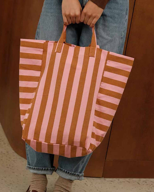 Tote Bag ELISABETH in Strawberry/Caramel Stripes, an beiden Henkeln vor einer Jeans gehalten