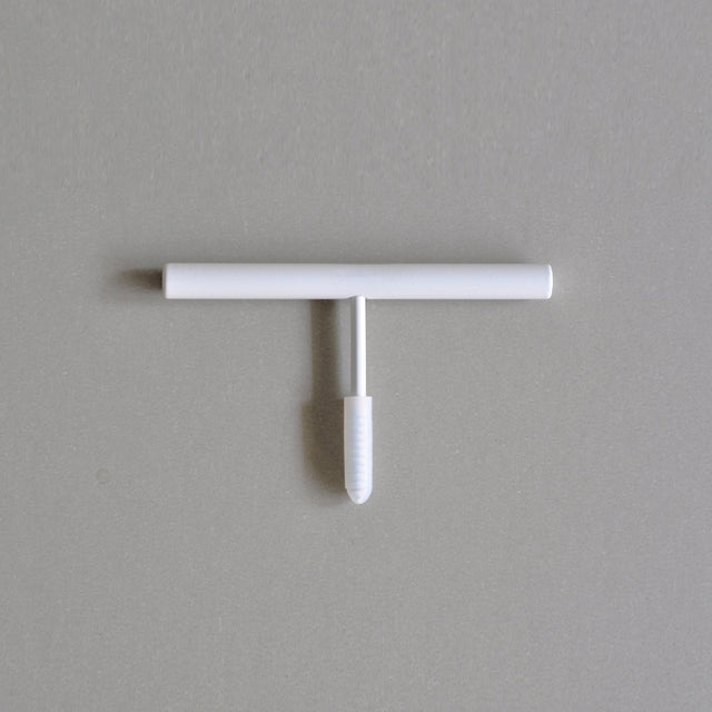 Weißer Wandhaken zum Einschrauben in die Wand. Die geradlinige Form erinnert an einen Strich.