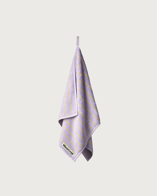 Gästehandtuch in Lilac & Neon Yellow hängt an seiner Aufhängeschlaufe