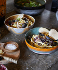 Zwei Pasta Bowls GOLDEN HOUR mit Bandnudeln, Muscheln und Kräutern auf einer Küchenarbeitsplatte