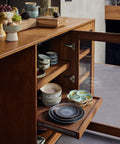 Sideboard mit geöffneten Auszügen, darauf der Dessertteller MINERAL und weiteres 70s-Ceramics-Geschirr