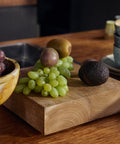 Teakholz-Sockel mit Weintrauben, Kiwi und Avocado auf einer Küchenarbeitsplatte