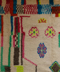 Detail mit drei Blumen in Pink, Gelb und Blau zwischen bunten Streifen