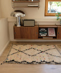 Kleiner Beni Ourain MINI DOTTIE 1,00 x 1,50 m im Raum: cremeweißer Flor mit schwarzen Rauten und bunten Punkten