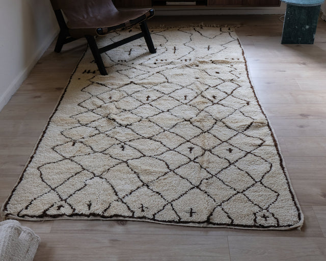 Berberteppich TRIBAL 1,53 x 2,62 m im Raum vor einem braunen Ledersessel
