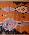 Detail: Figuren in Flieder und Cremeweiß mit rotem Kreuz auf orangefarbenem Grund
