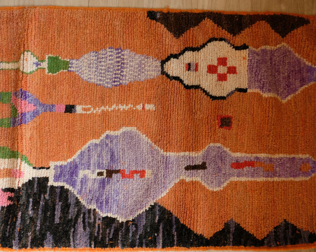 Detail: Figuren in Flieder und Cremeweiß mit rotem Kreuz auf orangefarbenem Grund