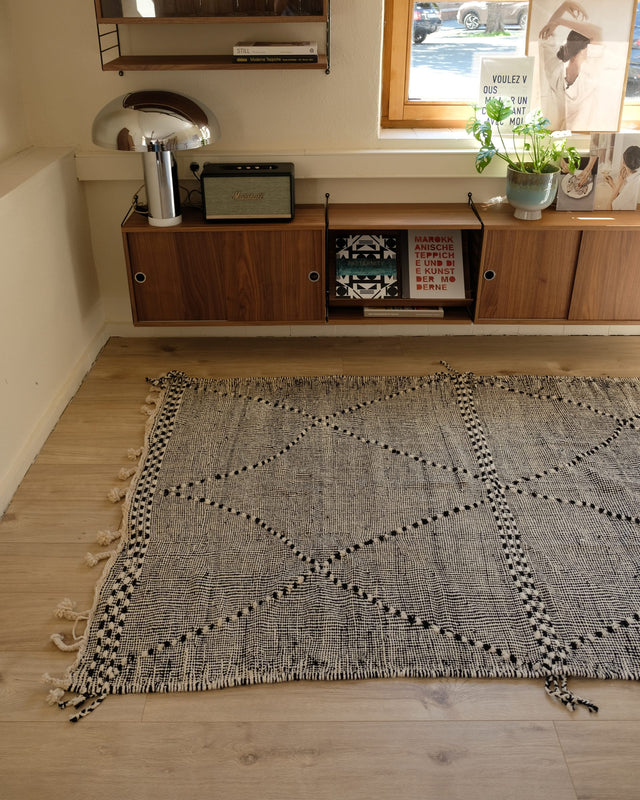 Zanafi in Schwarz-Weiß von der Schmalseite aus gesehen, dahinter ein Sideboard aus Holz