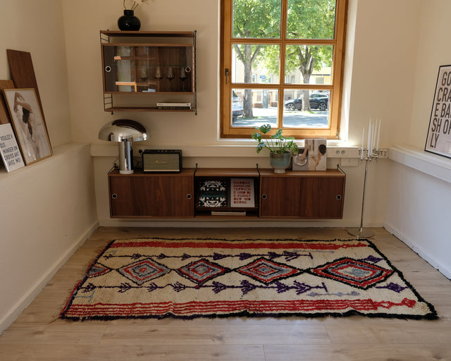 Vintage-Azilal-Teppich in Weiß, Rot und Lila vor einem Sideboard aus Nussbaum, Raum mit Fenster