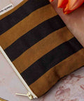Geldbeutel MARIE Stripes Cumin auf Marmor neben orangefarbenen Tulpen