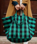 Tote Bag ELISA in Big Vichy Green, mit beiden Händen vor einem Mantel gehalten