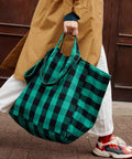 Tote Bag ELISA in Big Vichy Green in der Hand getragen, darunter rote Turnschuhe