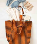 Tote Bag ELISABETH in Ginger Tennis Stripes, gepackt mit Handtuch, Sonnencreme, Zeitschrift und Bikini
