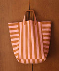 Tote Bag ELISABETH von Rose in April mit breiten Streifen in Rosa und Karamell vor einer Holzwand