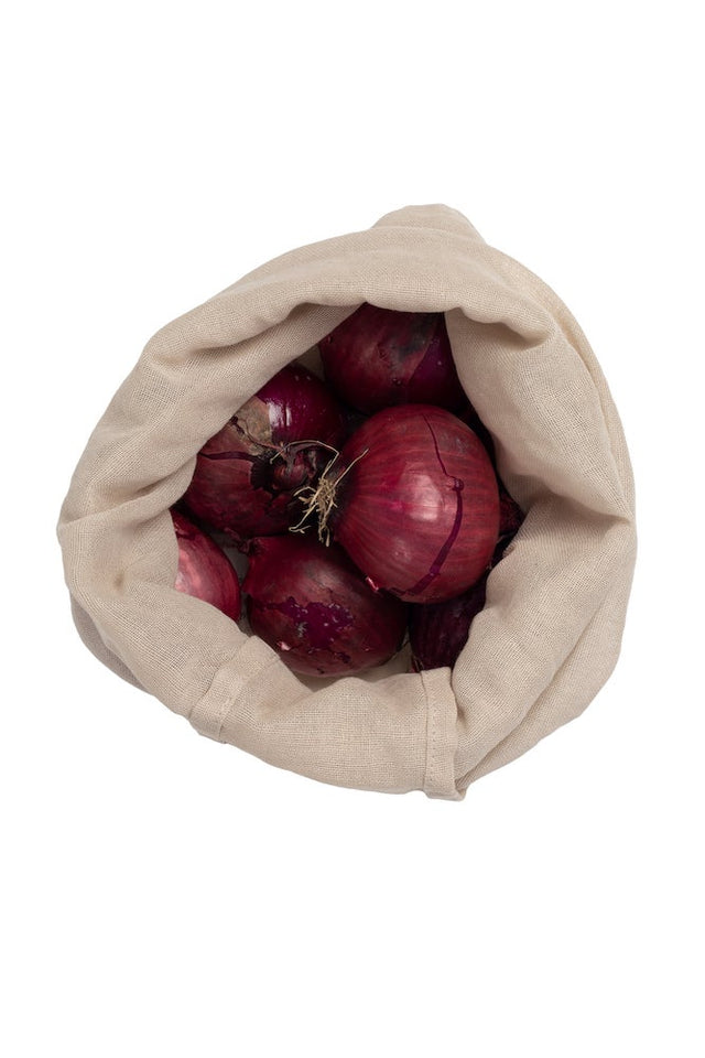 Stoffbeutel aus 100% Bio-Baumwolle in der Farbe Stone, gefüllt mit roten Zwiebeln. 