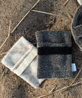 Beide Farben des KIVI Waschlappens nebeneinander auf Sandboden